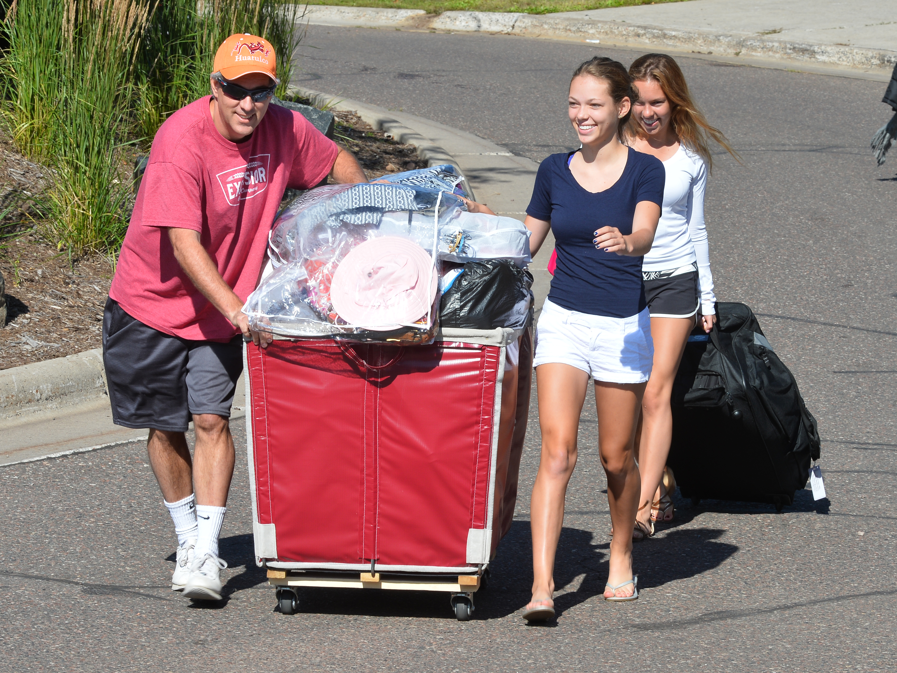 Family pushing move-in cart with items
